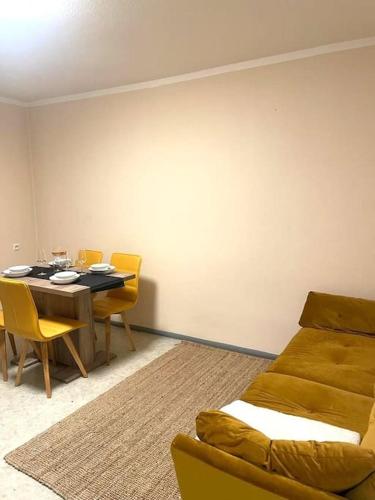 - une salle à manger avec une table et un canapé dans l'établissement Messe - Augsburg - Zentrum - 2 Zimmer - 3 Personen, à Augsbourg