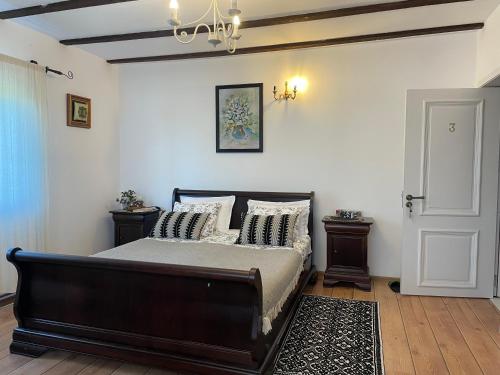 a bedroom with a bed with pillows on it at Conacul Paloși in Horezu