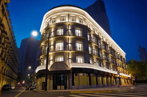 a large white building with windows on a city street at Opartment - People's Square 远东饭店 - 人民广场 in Shanghai
