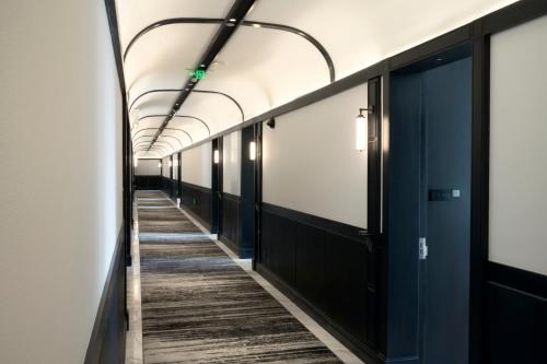 an empty corridor in an office building with black doors at Opartment - People's Square 远东饭店 - 人民广场 in Shanghai