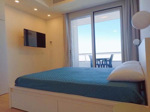 a bedroom with a bed with a view of the ocean at Le Conchiglie Residence in Porto Torres