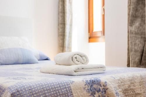a stack of towels sitting on a bed at Ca Sa Pradine in Alcudia