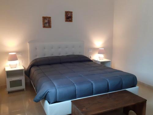 sypialnia z dużym niebieskim łóżkiem i 2 stolikami nocnymi w obiekcie Casa Salera w mieście Lonato