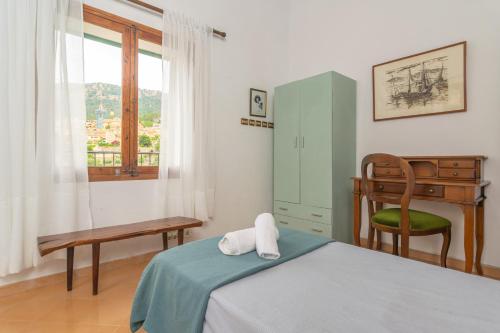 a bedroom with a bed and a desk and a chair at Casa Miranda in Valldemossa