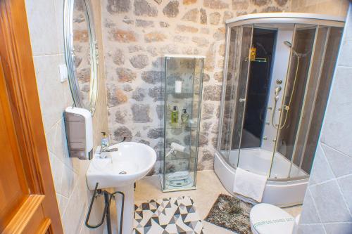a bathroom with a sink and a shower at Pallazo Uniqato seafront in Kotor