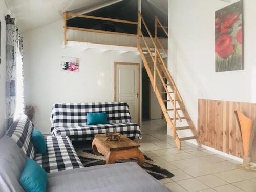 a living room with two couches and a wooden table at Location Villa pleine Nature Domaine des Radiers in Sainte-Rose