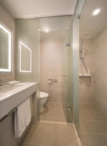 a bathroom with a shower and a sink and a toilet at Grab The Ocean Songdo in Busan