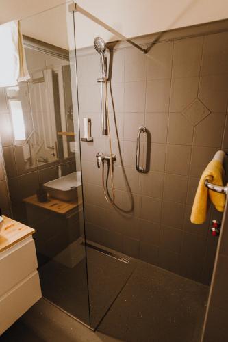 a bathroom with a shower with a glass door at Hotel Piano in Szeged