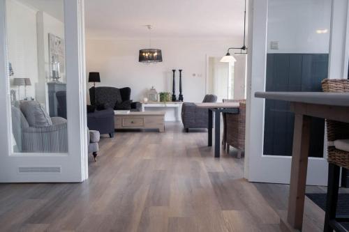 a living room with wood floors and a living room with a dining room at Vakantiebungalow Limmen in Limmen