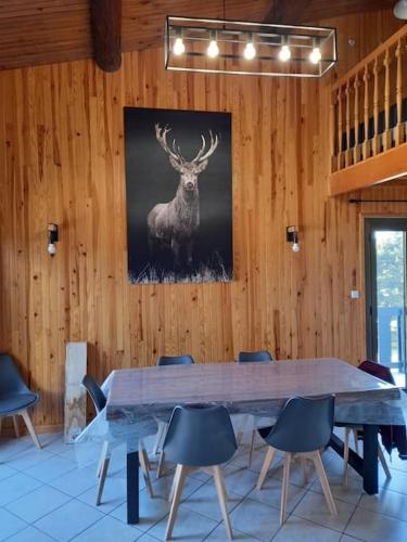 une grande table en bois avec des chaises et une photo de cerf dans l'établissement Appartement T4 Duplex Bolquère, à Bolquère-Pyrénées 2000