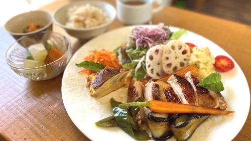 a plate of food with meat and vegetables on a table at Global Resort Misen - グローバルリゾート弥山 in Hatsukaichi