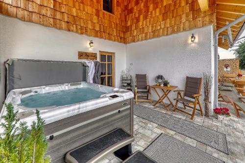 a hot tub in a patio with a table and chairs at Chalet Zur Wildrose in Freyung