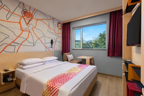 um quarto de hotel com uma cama e uma televisão em Ginger Jamshedpur em Jamshedpur