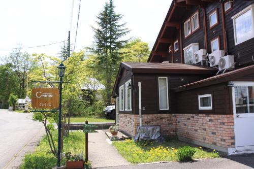ein Haus mit einem Schild davor in der Unterkunft Urabandai Cranes in Kitashiobara