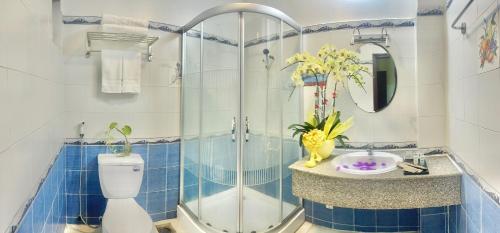 y baño con ducha, aseo y lavamanos. en Hải Nam Hotel (Sài Gòn), en Ho Chi Minh