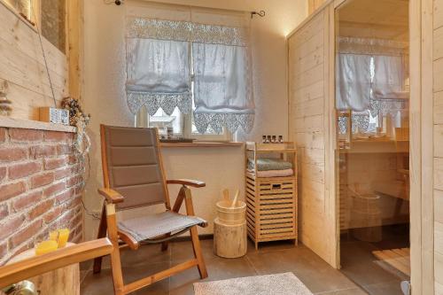 een kamer met een schommelstoel en een raam bij Chalet Zur Wildrose in Freyung