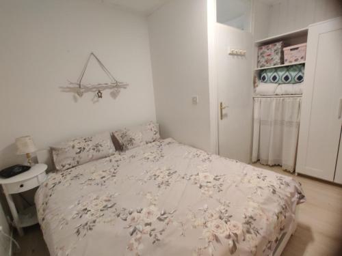 1 dormitorio con 1 cama con colcha de flores en Apartment Lilija en Bovec