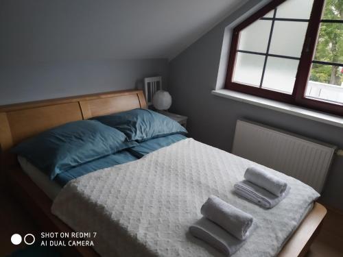 een slaapkamer met een bed met twee handdoeken erop bij Apartament przy Słonecznej in Szczyrk