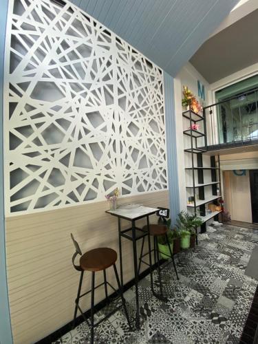 a white wall with a table and two stools at Jeboutiquelangsuan hotel in Lang Suan