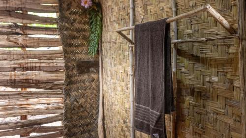 a bathroom with a towel hanging on a wall at The Asaro Mudmen Tribal Eco Lodge 