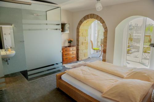 ein Schlafzimmer mit einem großen Bett und einem Waschbecken in der Unterkunft Plantagengut Hosterwitz in Dresden