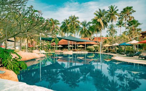 a pool at a resort with palm trees at Pelangi Beach Resort & Spa, Langkawi in Pantai Cenang