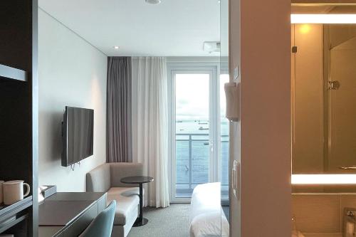 a hotel room with a bed and a window at Grab The Ocean Songdo in Busan