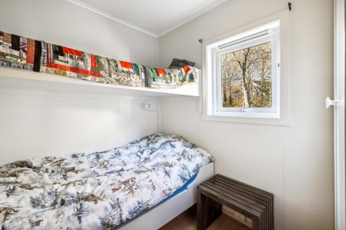 - une petite chambre avec un lit et une fenêtre dans l'établissement Hytte i Saltstraumen, à Bodø