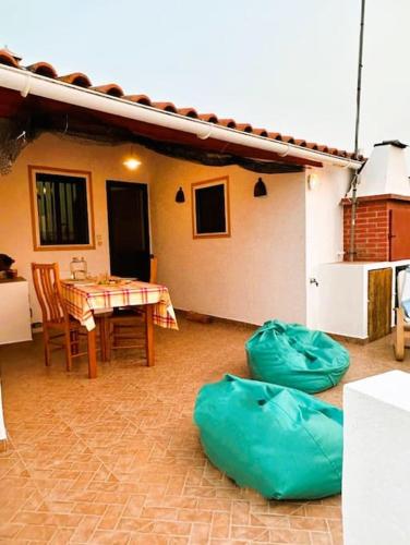 a patio with a table and chairs and a house at Casa dos AVÓS in Santana de Cambas