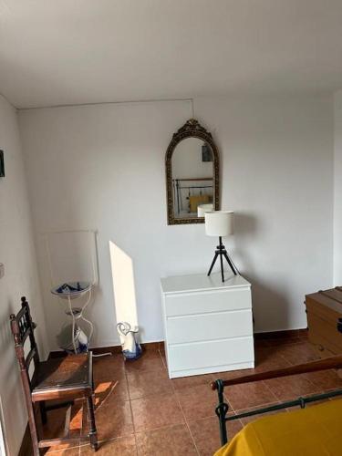 a room with a mirror and a dresser and a chair at Casa dos AVÓS in Santana de Cambas