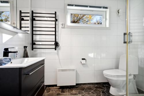 ein Badezimmer mit Toilette und Waschbecken und einem Fenster in der Unterkunft Hytte i Saltstraumen in Bodø