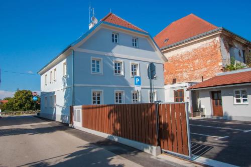 a blue and white building next to a fence at Apartmani Kac in Karlovac