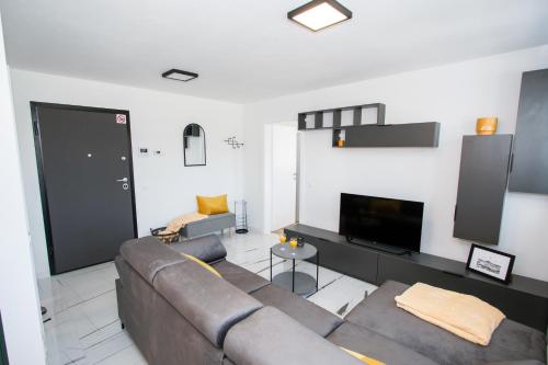 a living room with a couch and a flat screen tv at Apartmani Kac in Karlovac