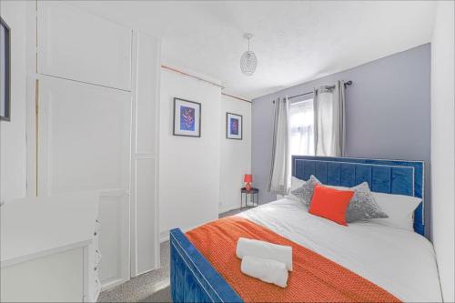 Un dormitorio con una cama azul y blanca con almohadas rojas en The Marsden - Modern 3 bed, Virgin TV, WIFI, en Edmonton