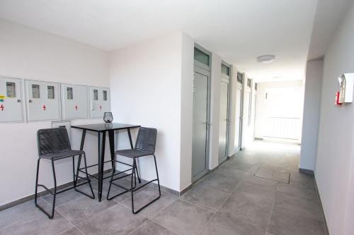 a room with a table and two chairs in it at Apartmani Kac in Karlovac