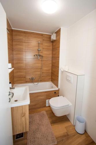 a bathroom with a white toilet and a sink at Apartmani Kac in Karlovac