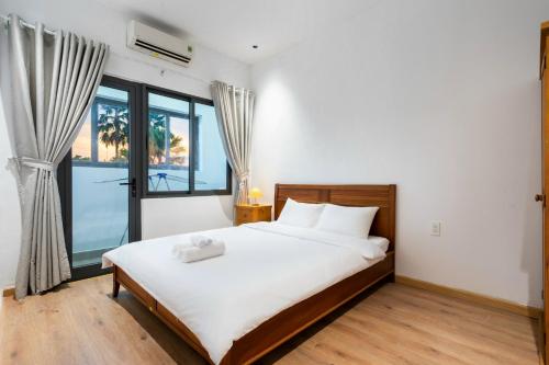 Un dormitorio con una cama y una ventana grande. en Tin Tin Apartment, en Ho Chi Minh