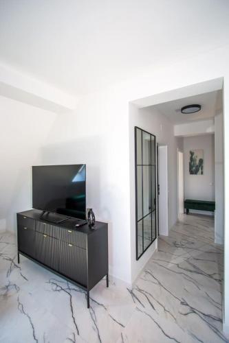 a living room with a television on a marble floor at Apartmani Kac in Karlovac