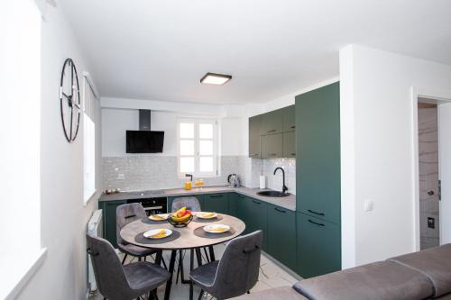 a kitchen with a table and chairs in a room at Apartmani Kac in Karlovac