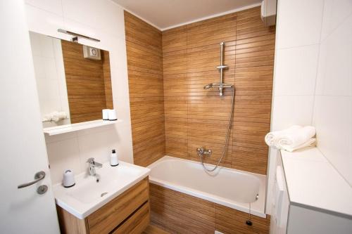 a bathroom with a tub and a sink and a shower at Apartmani Kac in Karlovac