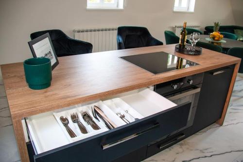 a table with a drawer with silverware on it at Apartmani Kac in Karlovac