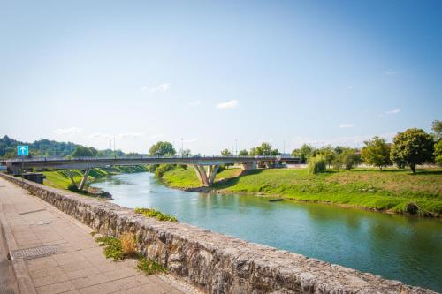 a bridge over a river next to a sidewalk at Apartmani Kac in Karlovac