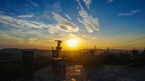 a sunset from a balcony with the sun in the sky at B&B La Buonora in Sinio