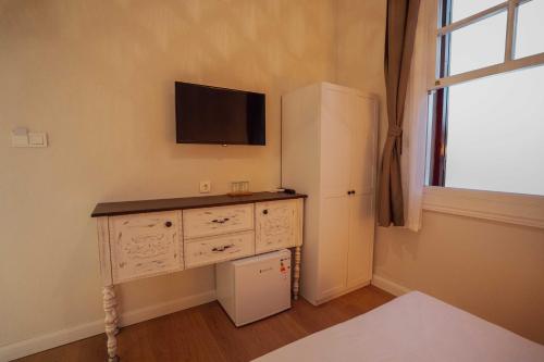 Pokój ten wyposażony jest w biurko, telewizor i lodówkę. w obiekcie Ivy Ayvalık Butik Otel w mieście Ayvalık