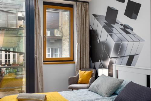 een slaapkamer met een bed, een stoel en een raam bij Downtown Cube Apartment in Boedapest
