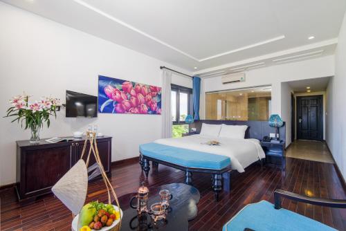 a hotel room with a bed and a table at Thanh Binh Riverside Hoi An in Hoi An