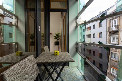 un balcone con due tavoli e sedie su un edificio di Downtown Cube Apartment a Budapest