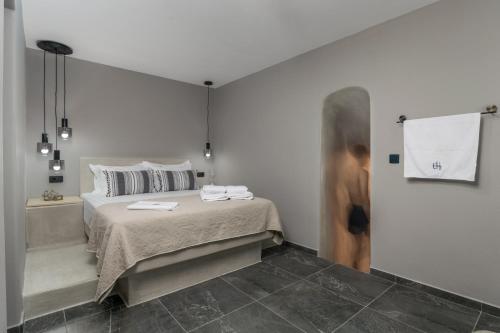 a bedroom with a bed and a bathtub and a person at Uncle's House luxury Suites in Adamas