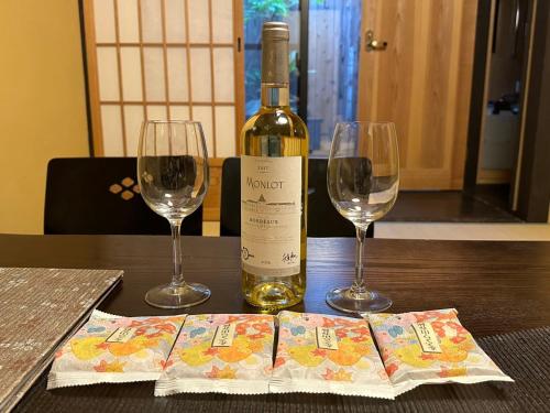 a bottle of wine and two glasses on a table at Miro Hachijo Uchidacho Tei in Kyoto