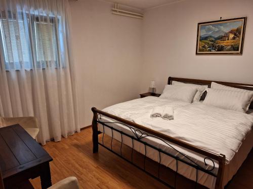 sypialnia z łóżkiem z białą pościelą i oknem w obiekcie Residence Nature's Symphony w mieście Sečovlje